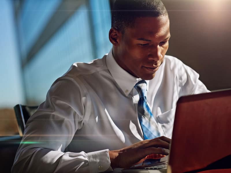 man in suit using laptop